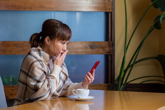 スマホを見て驚く女性